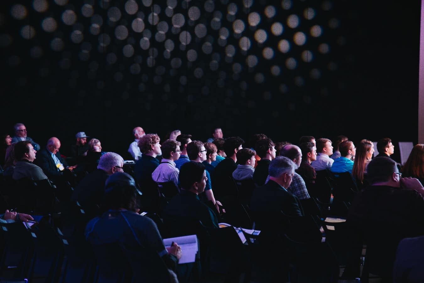 Public qui assiste à une présentation dans une salle de conférence