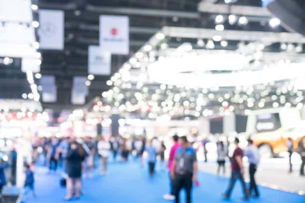 Foule qui déambule parmi les stands d'un salon professionnel